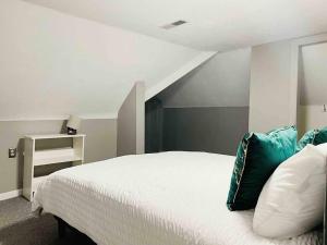 a bedroom with a white bed with blue pillows at Leaning House of Haynie in Evansville