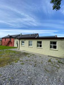 a yellow house with a black roof at Beautiful 2-Bed Apartment in Lisselton