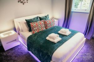 a bedroom with two towels on a bed with a couch at Princes st by Prestige Properties SA in Ulverston