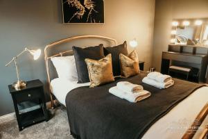 a bedroom with a large bed with towels on it at Princes st by Prestige Properties SA in Ulverston