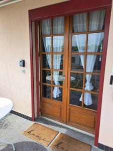 drewniane drzwi z zasłonami w pokoju w obiekcie T2 AVEC TERRASSE w mieście Oloron-Sainte-Marie