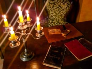 un tavolo con candele, un libro e una sedia di L'Antica Dimora a Macchiagodena