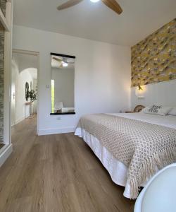 a white bedroom with a large bed and a mirror at Apartamento PLAYA LAS VENTANICAS in Mojácar