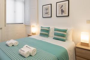 een slaapkamer met een bed met drie handdoeken erop bij Modern Studios with Terrace - Walk Everywhere in Porto