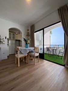 ein Wohnzimmer mit einem Tisch und Stühlen sowie eine Küche in der Unterkunft Apartamento PLAYA LAS VENTANICAS in Mojácar