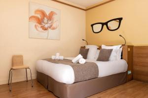 a bedroom with a bed with sunglasses on the wall at Hotel Le Dauphin in Honfleur