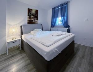 1 dormitorio con 1 cama grande y cortinas azules en Restaurant Donau, en Hannover