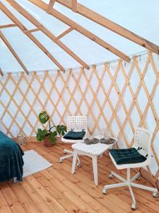 una habitación con 2 sillas y una mesa en una yurta en Glamping Yurt Purvs at Kleja Quiet Camping en Eikaži