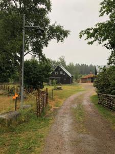 un camino de tierra que conduce a un granero y una casa en Charming holiday apartment on a rural farm outside Laholm, en Laholm