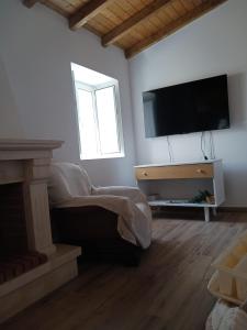 a living room with a flat screen tv on the wall at A Casa do Barqueiro- Alentejo in Pedrógão