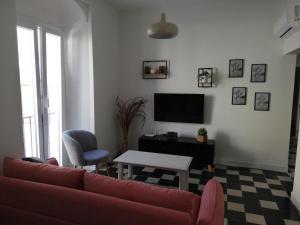 a living room with a red couch and a table at Apartamento Arco´s House in Sanlúcar de Barrameda