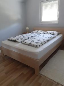 1 cama en un dormitorio con ventana en Tihanyi Vendégház, en Villánykövesd