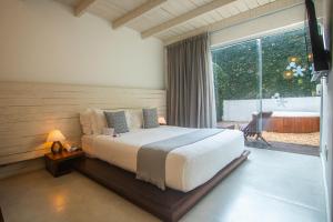 a bedroom with a bed and a large window at Serena Buzios in Búzios