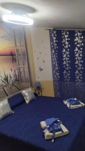 Un dormitorio con una cama azul con toallas. en Splendido Attico, en Roseto Capo Spulico