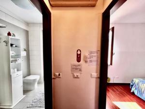 a bathroom with a toilet and a door in a room at Casanova Loc Turistica in Verona