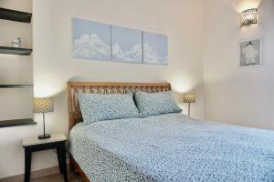 ヴァッレクロージアにあるVilla Angelina - Casa Glicineのベッドルーム1室(青い掛け布団、ランプ2つ付)