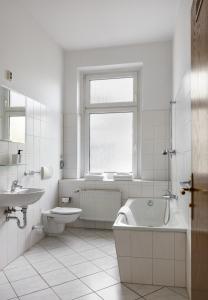 a white bathroom with a tub and a sink at Hotel Nova in Berlin