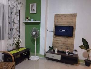 sala de estar con TV de pantalla plana en la pared en La Residencia Tacloban, en Tacloban