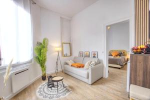 ein Wohnzimmer mit einem Sofa und einem Tisch in der Unterkunft Bright 30 m near the Place de la Comédie in Montpellier