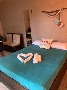 a bedroom with a bed with two slippers on it at Suíte 100m da praia e academia inclusa dias de semana in Maceió