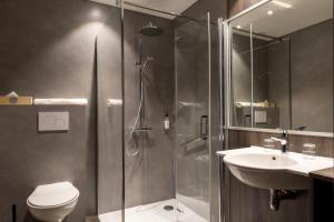 a bathroom with a shower and a toilet and a sink at Hotel Le Dauphin in Honfleur