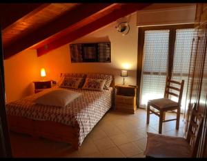 1 dormitorio con 1 cama, 1 silla y 1 ventana en B&B Su Canistreddu, en Alghero