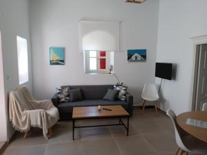 een woonkamer met een bank en een salontafel bij Perseids Traditional House in Amorgós