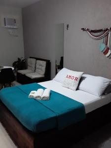 a bedroom with a bed with two towels on it at Suíte 100m da praia e academia inclusa dias de semana in Maceió