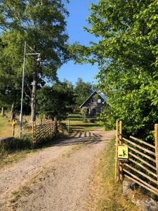 a dirt road with a fence and a barn at Nice apartment outside Laholm in rural idyll in Laholm