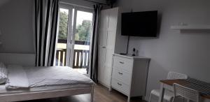 a bedroom with a bed and a large window at NASZE 4 KĄTY in Junoszyno