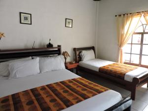 a bedroom with two beds and a window at Hotel Puerto Gaviota in Tonsupa