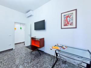 een kamer met een tafel, een stoel en een tv bij La Roscia House in Porto San Giorgio
