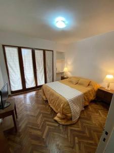 a bedroom with a large bed and two windows at Departamento Necochea in Rosario