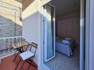 een balkon met een tafel, een bed en een raam bij La Roscia House in Porto San Giorgio