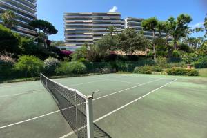 una pista de tenis con red en una pista de tenis en Comfortable cocoon with exceptional sea view, en Vallauris