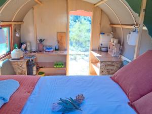 a bedroom with a bed and a kitchen in a caravan at Rangers Reserve in Touwsrivier +75 photos