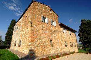um grande edifício de tijolos com janelas brancas em Villa Arnilù em San Gimignano
