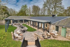 Un patio al aire libre con sillas y mesas y un edificio. en Springwood Holiday Park, en Kelso