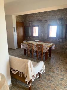 una sala da pranzo con tavoli, sedie e finestre di Mani Castle Houses a Mína