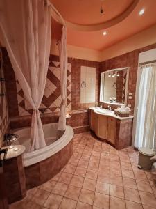 a large bathroom with a tub and a sink at Cozy Apartment in Volos