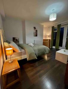 um quarto com uma cama e uma mesa com um candeeiro em Karen House R2 em Londres