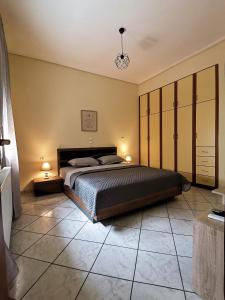 a bedroom with a large bed and two lamps at Cozy Apartment in Volos