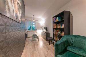 a living room with a green couch and a book shelf at Dom na Mazurach nad jeziorem Białym Zakątek Zacisze in Langendorf