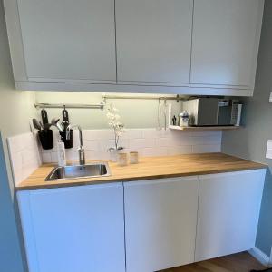 a kitchen with white cabinets and a sink at Studion in Falun +3 photos
