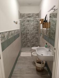 ein Bad mit einer Dusche, einem WC und einem Waschbecken in der Unterkunft Sabbia d'oro in Santa Maria Del Focallo