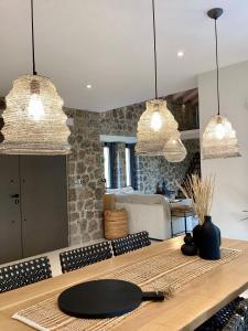 une cuisine avec trois lampes suspendues et une table en bois dans l'établissement Villa Tartaya, à Dassia