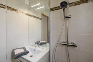 biała łazienka z prysznicem i umywalką w obiekcie Les Alpages 73 - Les Saisies w mieście Les Saisies