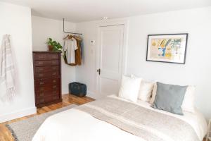 a bedroom with a bed and a dresser at Le Boulevard par Maison Dudley in Lac-Mégantic