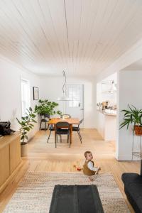 un bebé sentado en el suelo en una sala de estar en Le Boulevard par Maison Dudley en Lac-Mégantic