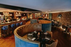 a restaurant with a table and a bar at Glasgow Grosvenor Hotel in Glasgow